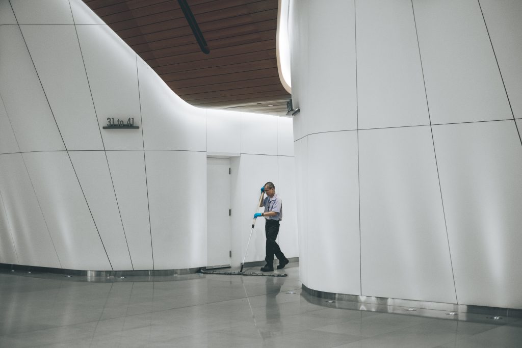 A worker cleaning the floor