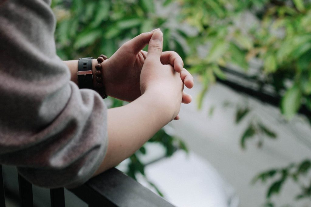 Hands of a person standing in his balcony