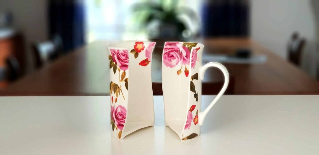 Two pieces of a broken cup standing on a table