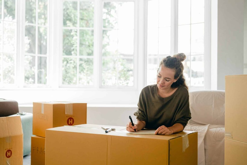 A lady is making a list of items for her comfortable new home