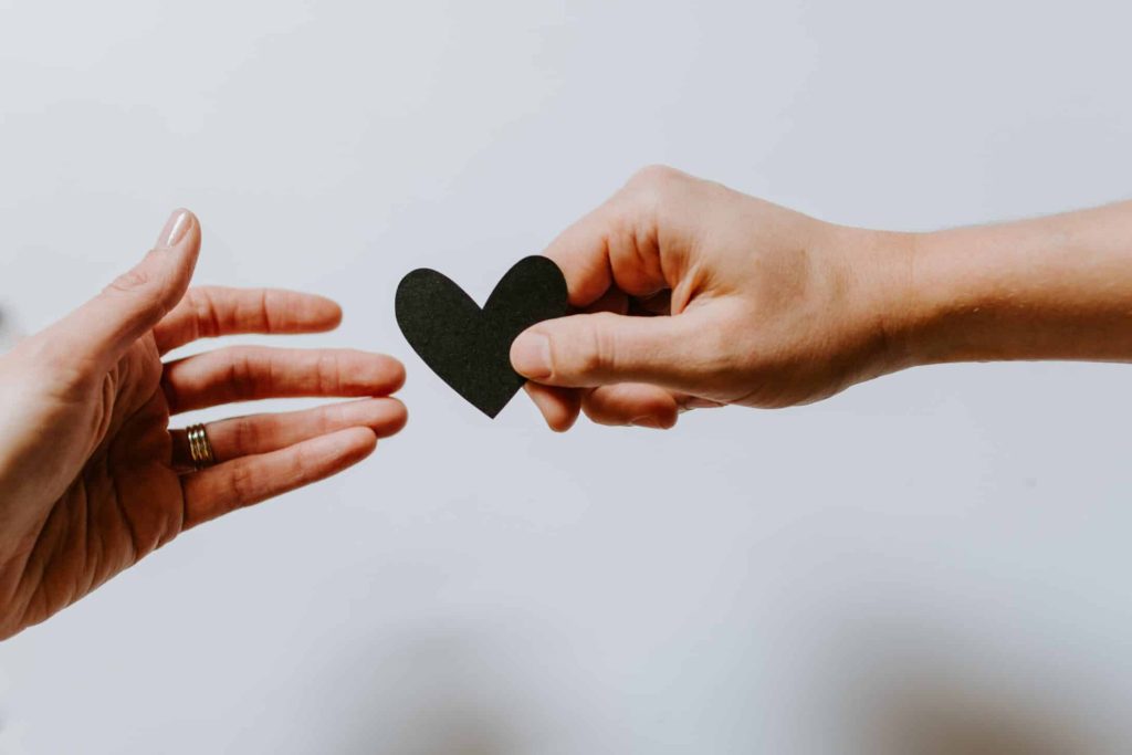 A man giving heart made of paper to a woman