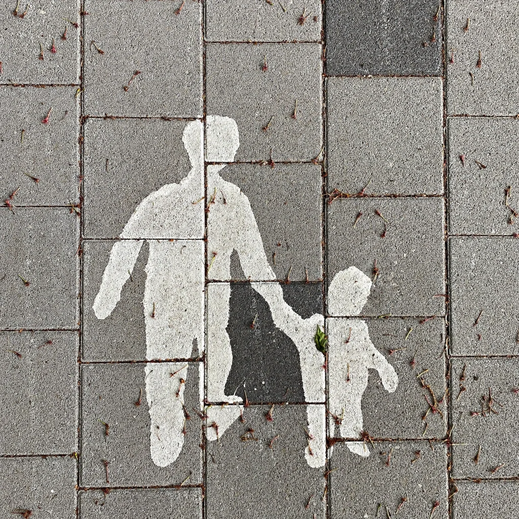 Shadow of father holding son's hand reflecting on wall