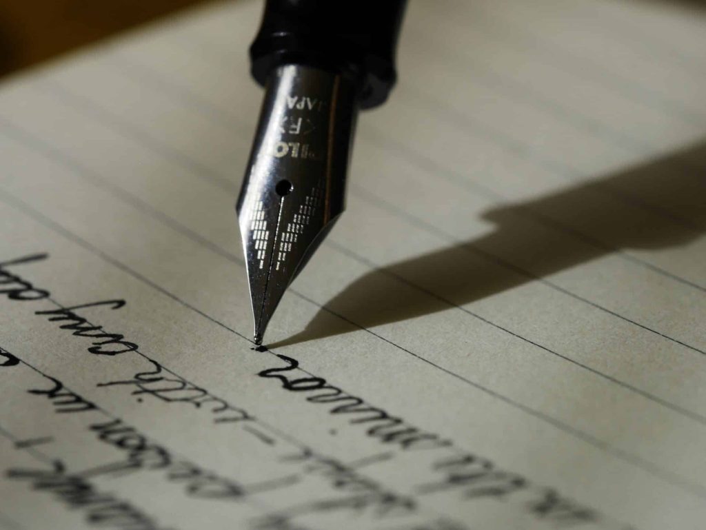 Someone is writing on a paper with pen