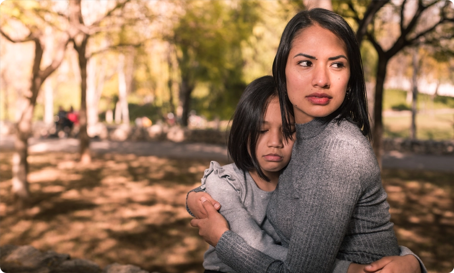 Mother comforting distraught daughter, offering emotional support as family copes with divorce caused by parent's infidelity