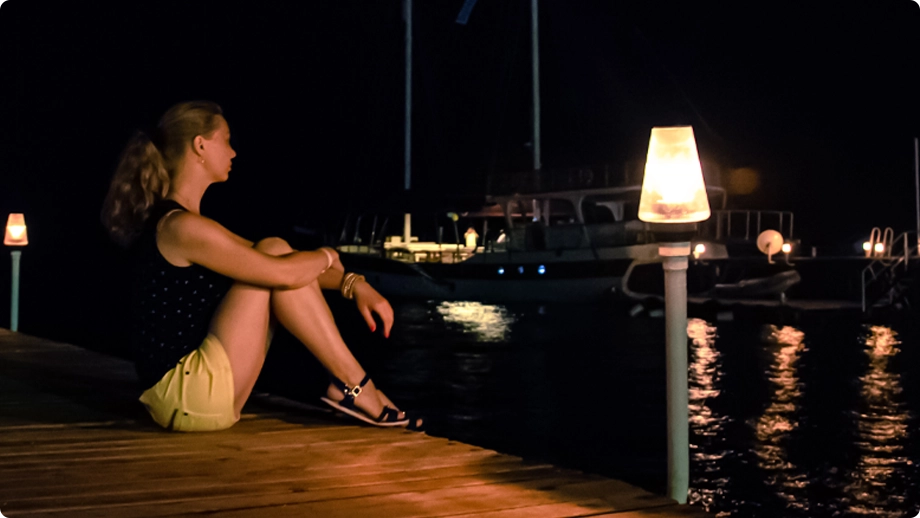 woman sitting on dock ruminating a divorce with Properties in multiple states