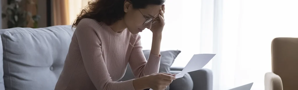 Frustrated woman reading a letter with bad news