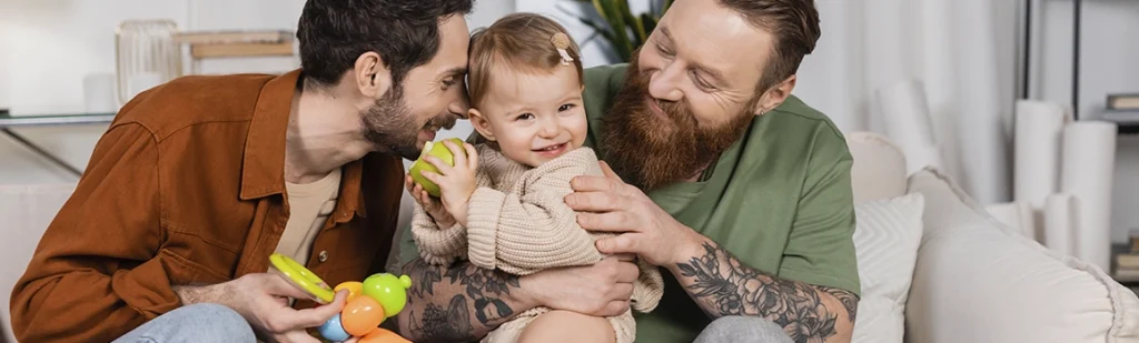 happy gay couple celebrating the arrival of their first adoptive child