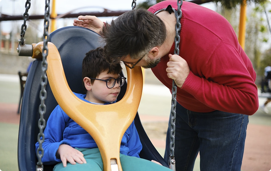 Disabled child communicating with his dad at the park