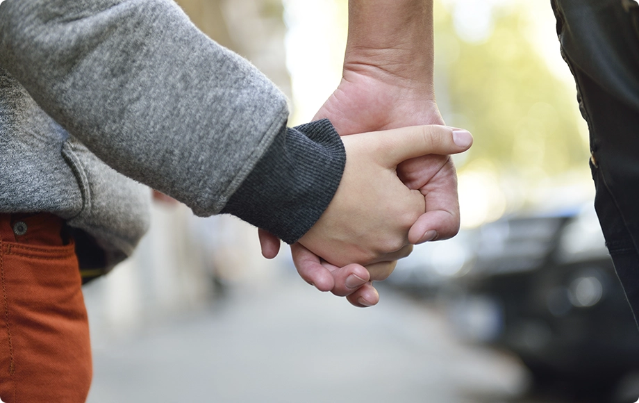 Hand of mother and son walking