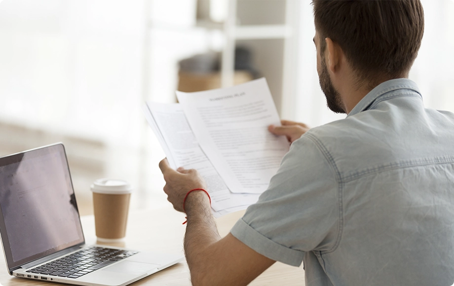 stressed man reading about divorce documentation at home
