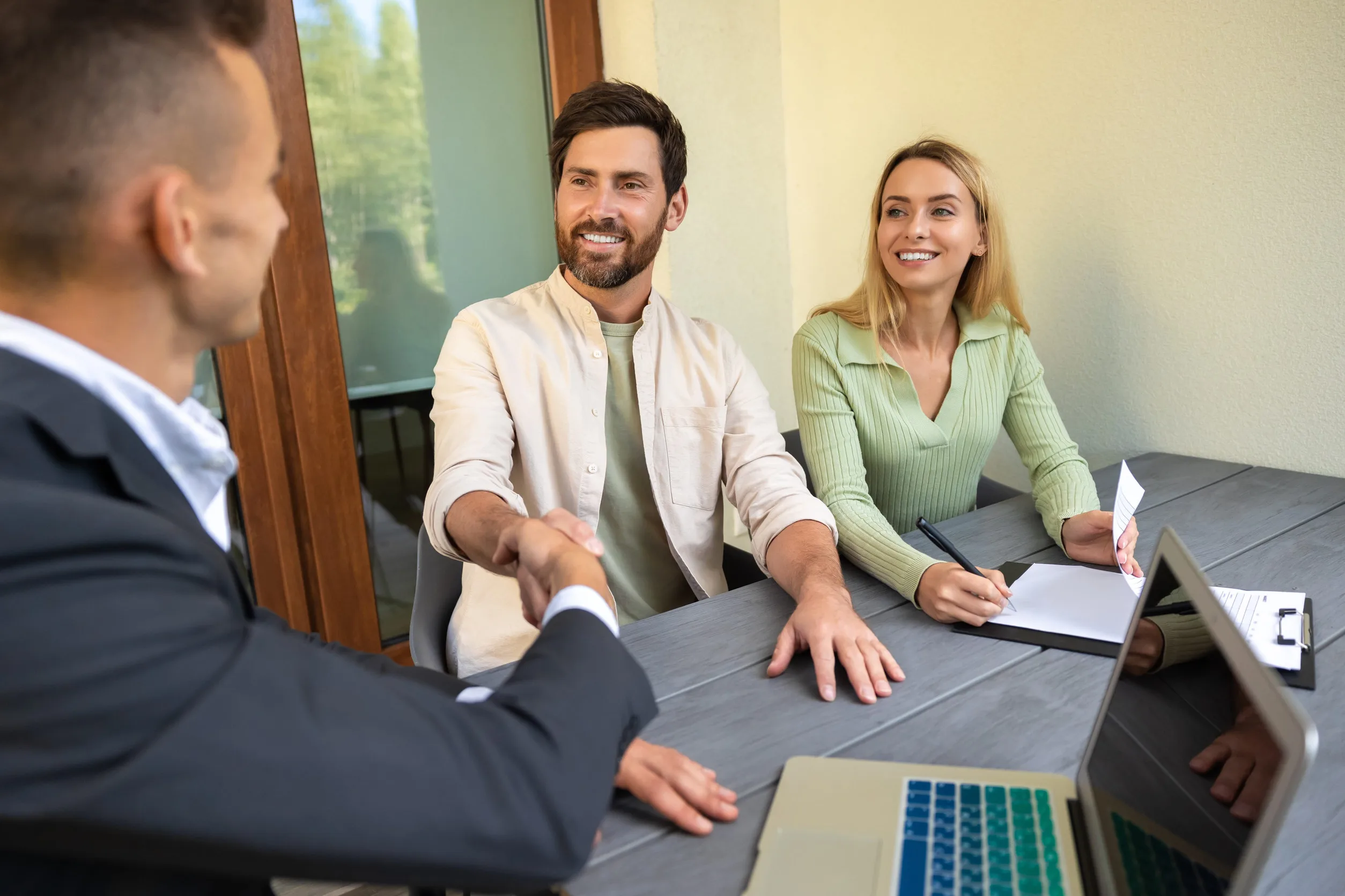 Two spouses and their collaborative divorce attorneys reviewing a settlement agreement